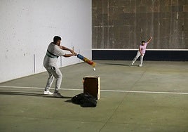 El bateador, delante del wicket, intenta devolver la pelota.