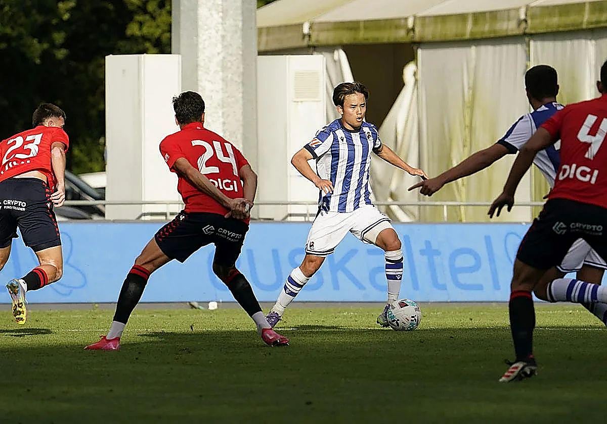Kubo, ante varios jugadores de Osasuna en el amistoso de la Real en pretemporada.