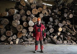 Daniel Zubillaga posa ante un montón de maderas almacenadas en su pabellón para que sean cortadas.