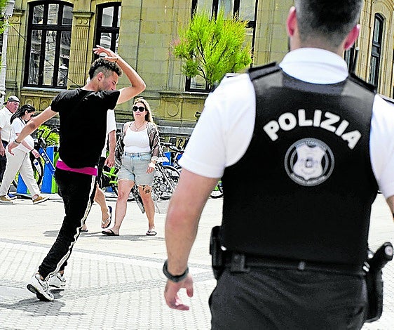 Un joven realiza un gesto despectivo a un guardia municipal.