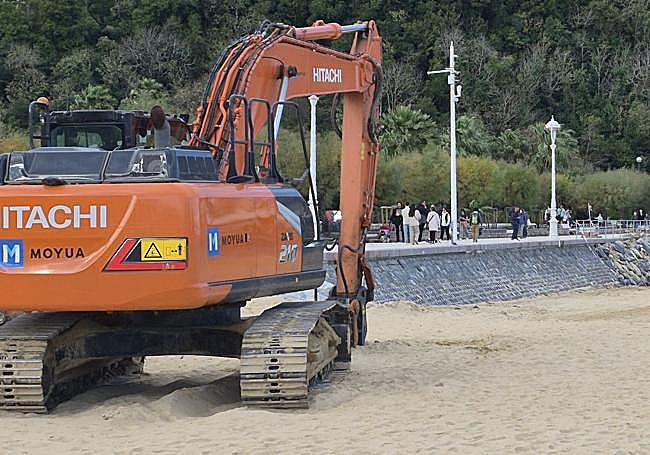 Una excavadora realiza trabajos previos en la zona, una vez retirados los restos de las escaleras de acceso a la playa.