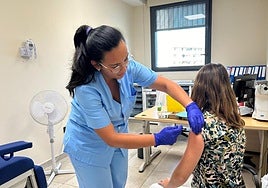 Una enfermera vacuna a una mujer.