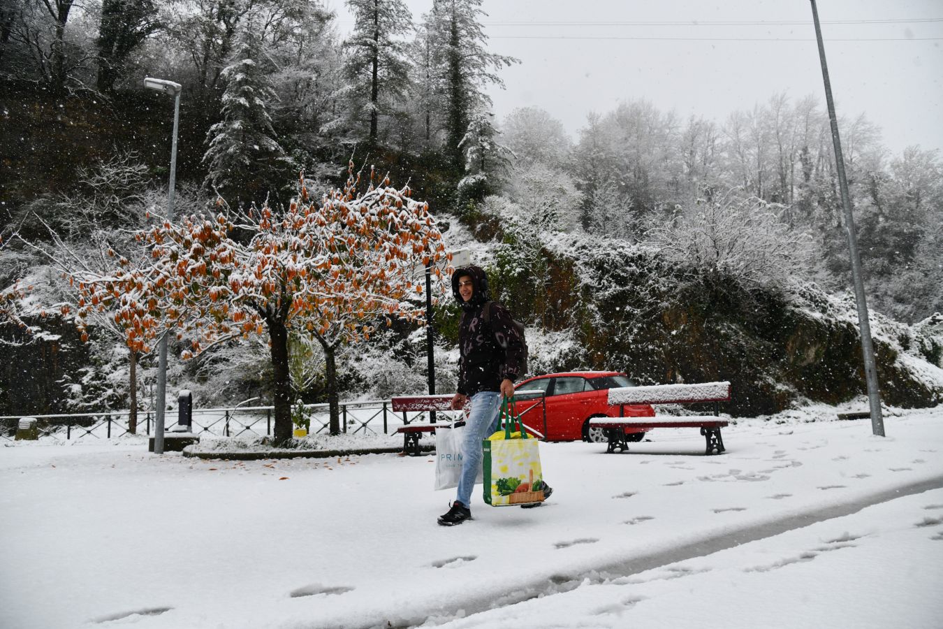 Una mujer pasea por Legazpi mientras los copos de nieve caen. 
