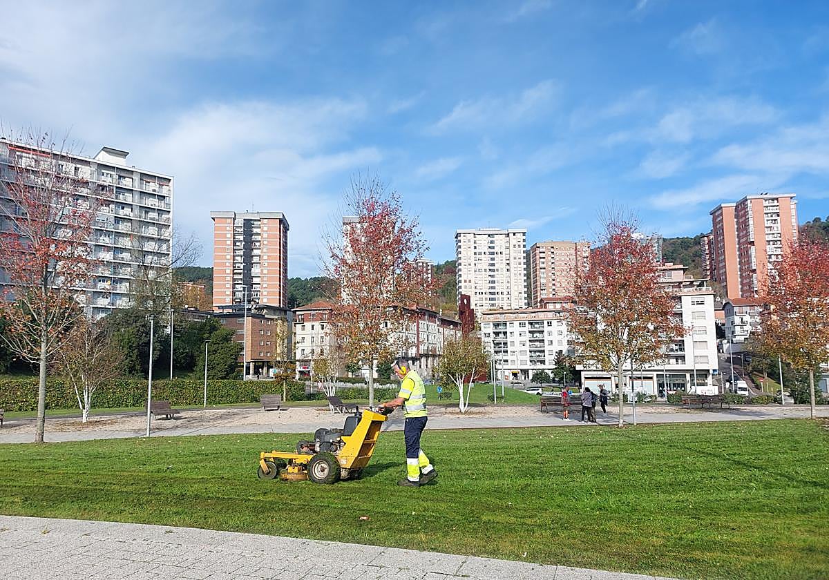 Un operario municipal se ocupa del mantenimiento de la zona verde de la pasarela peatonal y ciclista.