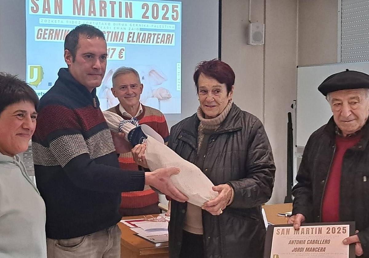 Entrega de uno de los dos jamones sorteados.