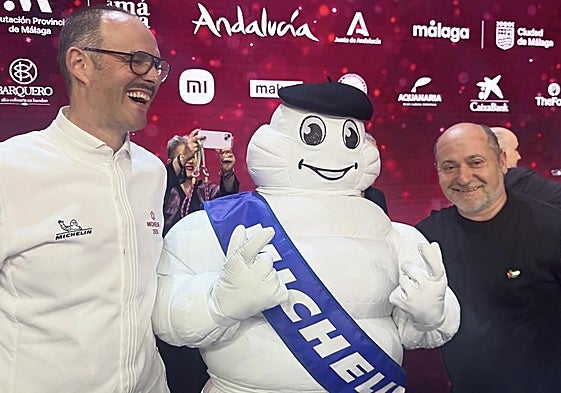 Roberto Ruiz coloca sobre el 'Bibendum' de Michelin su txapela, en la gala de Málaga, mientras ríe Iñigo Lavado