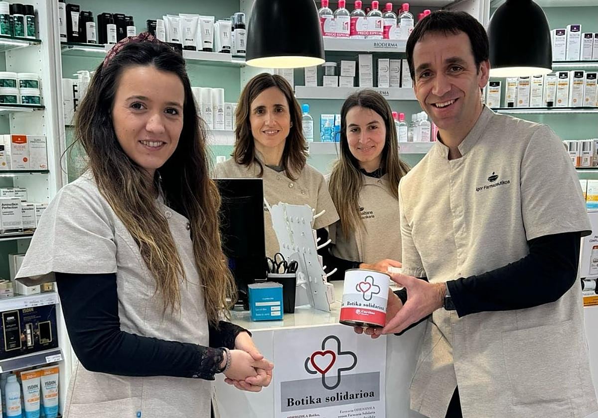Colaboración. Miembros de la Farmacia Odriozola, posan con la hucha de la campaña. cáritas
