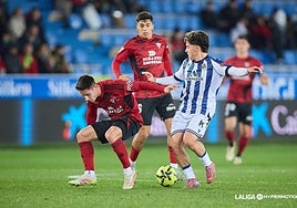 Dani Díaz trata de llevarse un balón ante la oposición de dos contrarios.