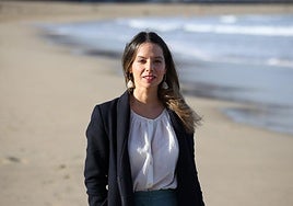 Lide Aguirre, con su libro, en la playa de La Zurriola de Donostia, en donde transcurre la trama.