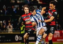 Gorka Carrera trata de zafarse del marcaje de dos futbolistas del Reus.