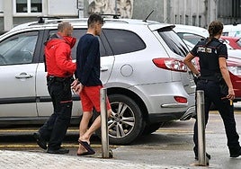 Dos ertzainas trasladan a un detenido en las inmediaciones del Hospital Donostia.