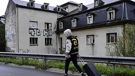 Uno de los jóvenes desalojados ayer por la mañana, con su maleta a cuestas, frente al instituto de Martutene donde residía hasta ahora.