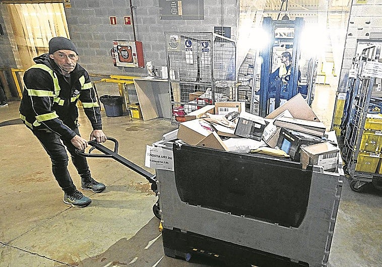 Un operario desplaza una de las cajas con paquetería voluminosa que descargó el trailer.