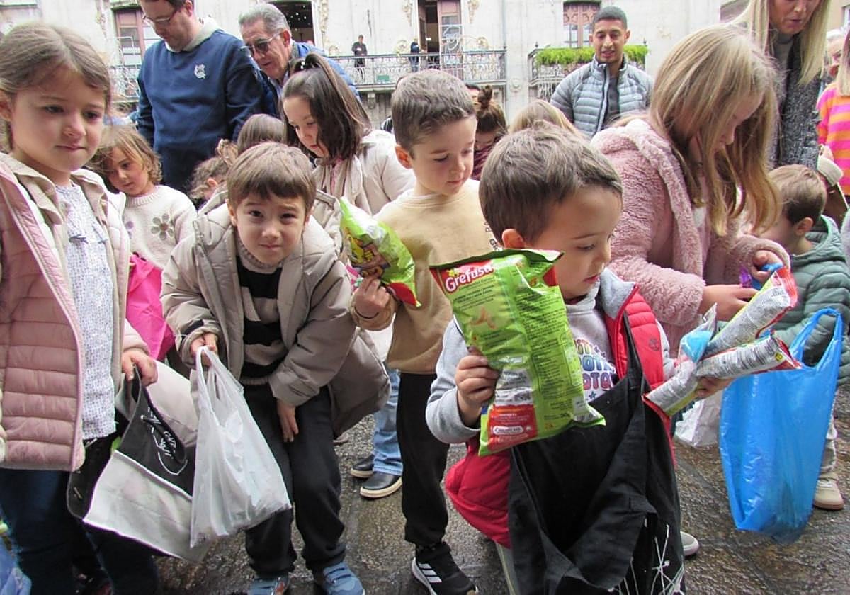 Aitor Isasa, de Goxo-Goxua , 'dirige' a la chavalería cantando la copla de San Nikolas. Al lado, unos pequeños hacen recuento del botín reunido en el bolo-bolo para los más txikis.
