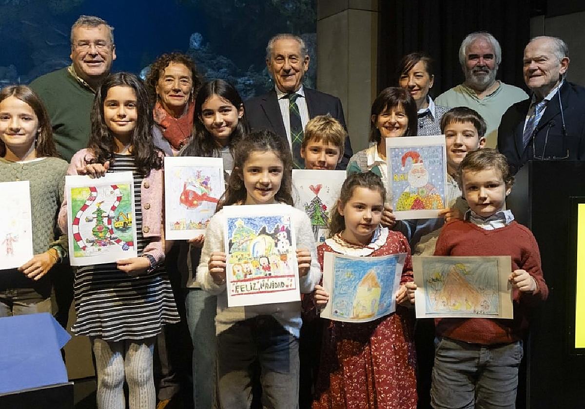 Los niños y niñas premiadas posan con sus dibujos navideños, junto a directivos del RAC.