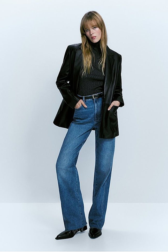 'Blazer' negra con pantalones vaqueros rectos y botines.