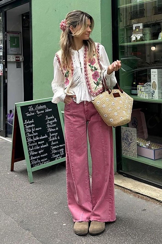 Camisa blanca con un chaleco de tonos rosas y beige con pantalones rosas.