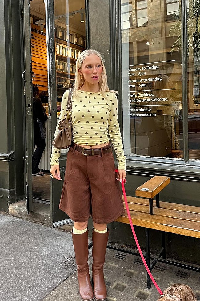 Look urbano con 'top' amarillo de puntos, bermudas color chocolate y botas altas.