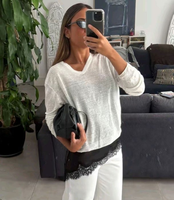Pantalón de lino blanco y jersey blanco sobre un 'top' asimétrico lencero.