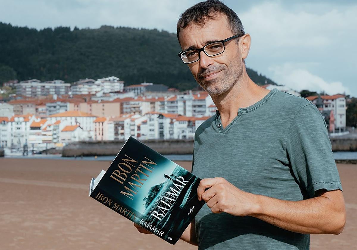 Ibon Martín posa con su libro en la playa de Lekeitio, escenario de la acción.