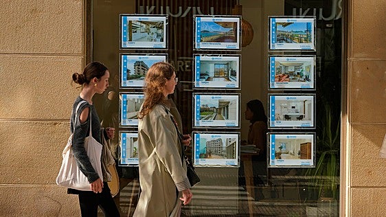 Dos mujeres pasan frente a un escaparate de una inmobiliaria guipuzcoana.