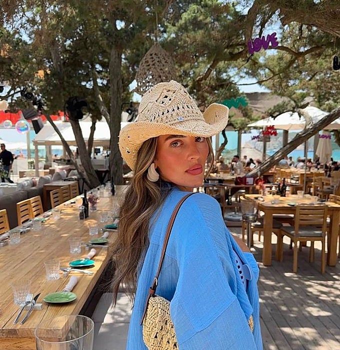 Mujer con sombrero y bolso de rafia.