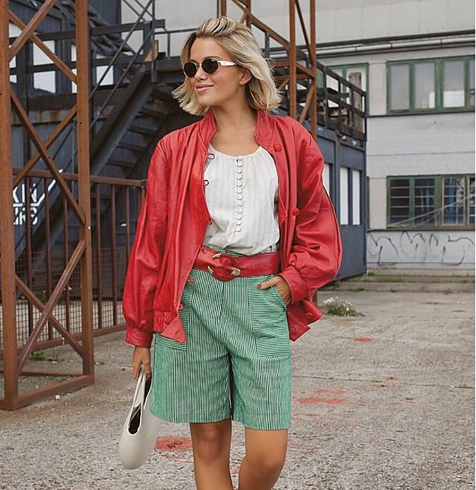 Chauqeta roja con un 'top' blanco y 'jorts' verdes de rayas.