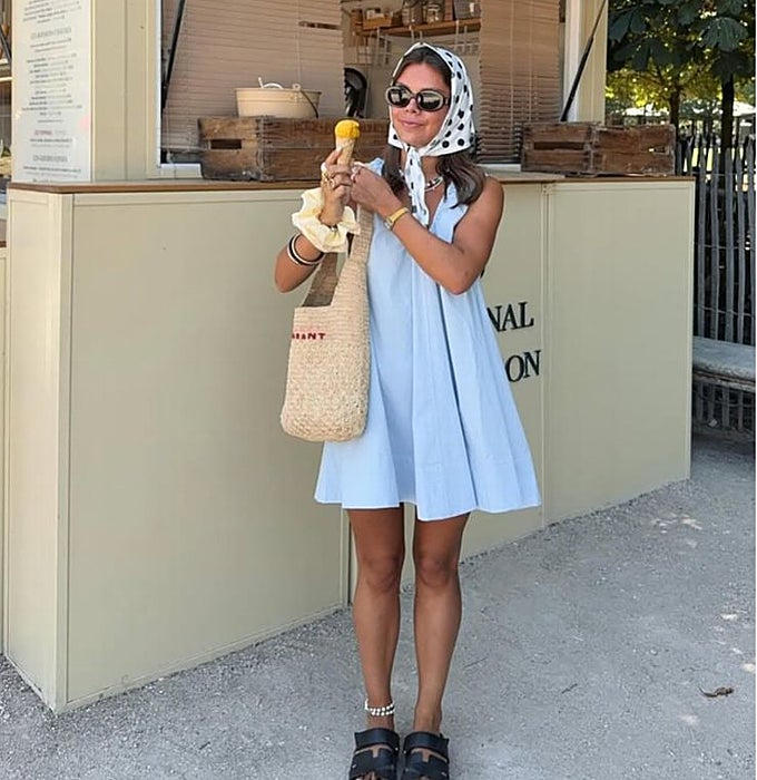Vestido corto en azul pastel con pañuelo de lunares en la cabeza.