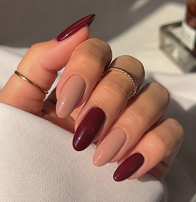 Manicura en colores burdeos y crema.