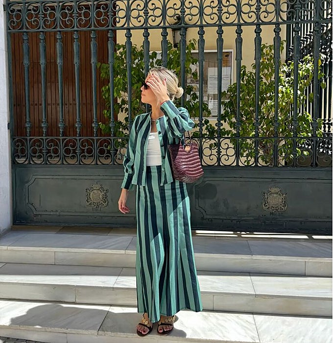 Chaqueta corta y falda larga con rayas verticales en verde agua y verde oscuro, 'top' blanco y bolso trenzado burdeos.
