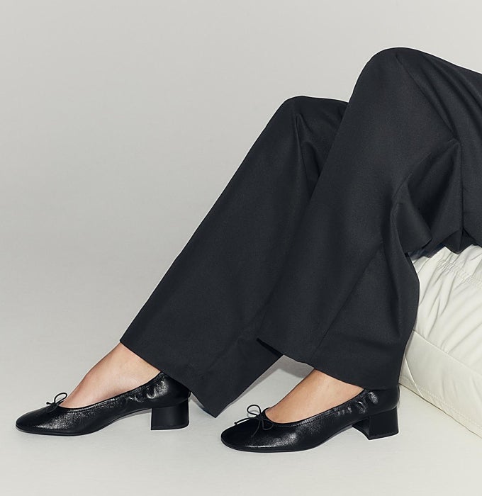 Pantalón de pinza negro y bailarina fruncida negra con tacón.