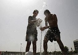 Dos jóvenes se refrescan en Córdoba. / Efe