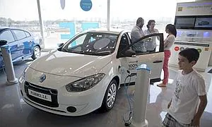 Una familia observa un coche eléctrico de la compañía estadounidense-israelí "Better Place" ./ Archivo