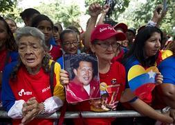 Partidarios de Hugo Chávez sostienen una foto del mandatario. / Juan Barreto (Afp)