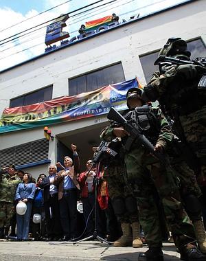 El vicepresidente boliviano habla junto a autoridades que custodian una de las principales oficinas de la distribuidora Electropaz./ M. Alipaz (Efe)