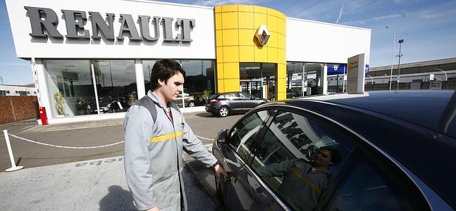 Un trabajador de Renault prueba un coche junto a un concesionario. / Archivo