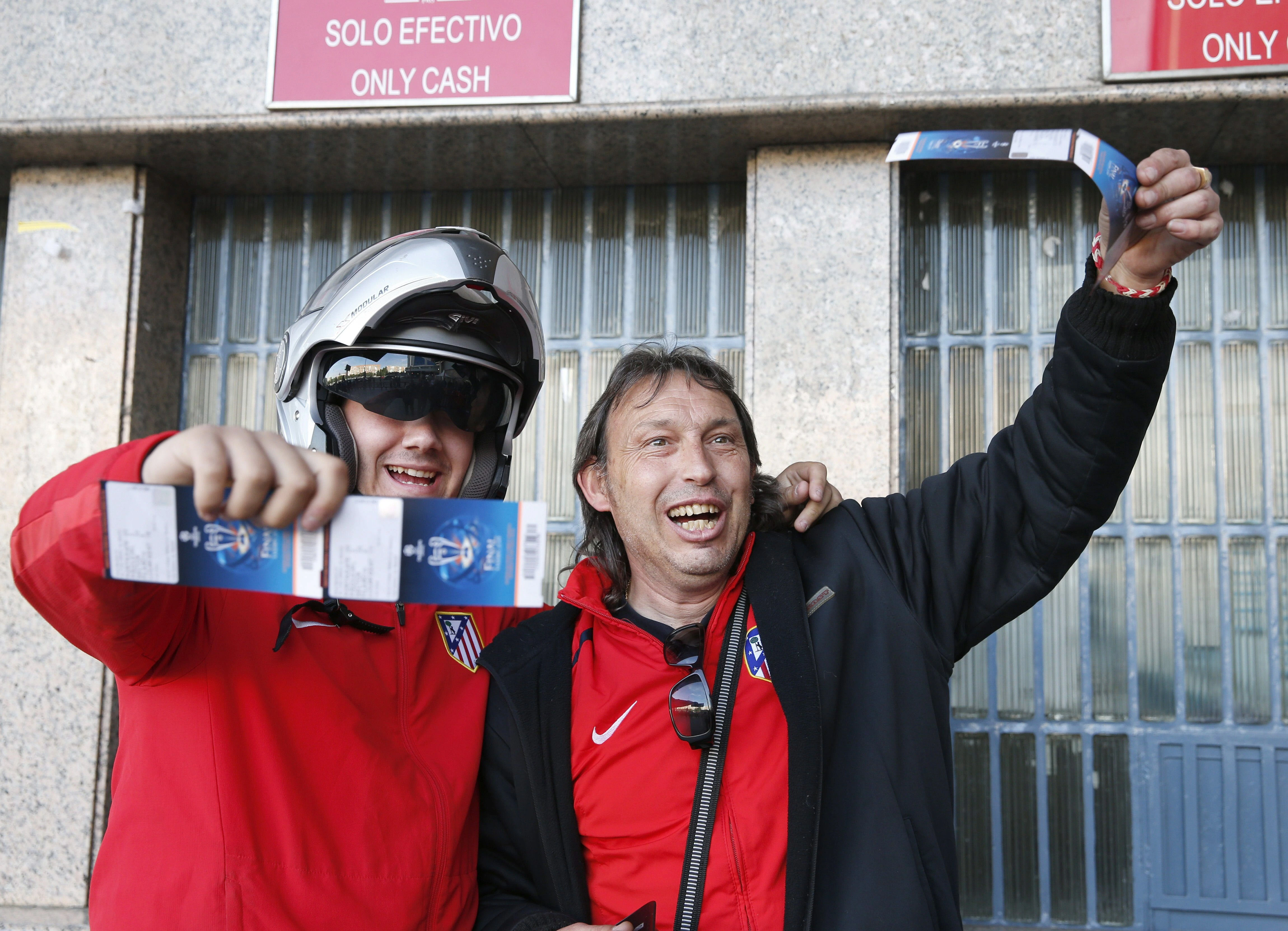 Dos aficionados del Atlético de Madrid muestran las entradas para la final.