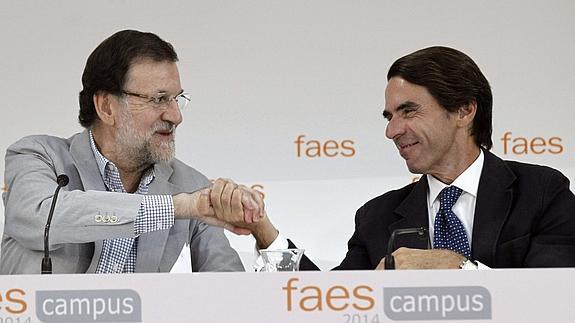 Rajoy estrecha la mano de Aznar.
