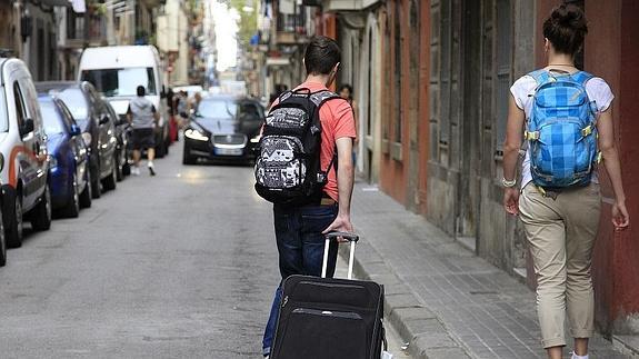 Dos turistas atraviesan el barrio de La Barceloneta. 