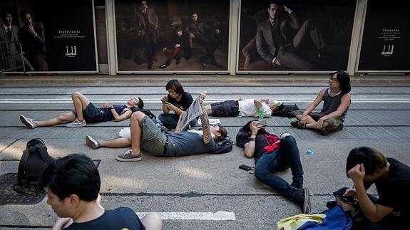 Algunos de los manifestantes descansan en la calle. 