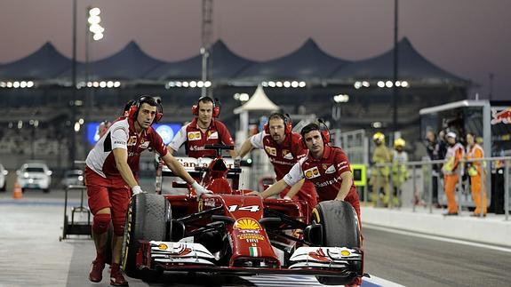 Mecánicos de Ferrari empujan el coche de Alonso.   Reuters