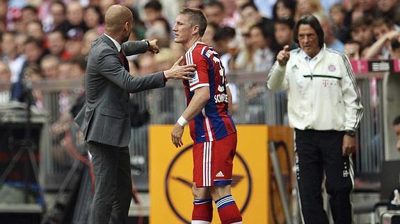 Guardiola (i) habla con Schweinsteiger y señala Müller-Wohlfahrt (d). 