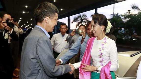 Aung San Suu Kyi saluda al embajador de China en Birmania, Yang Houlan, en el aeropuerto de Rangún.