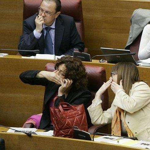 Parlamentarios valencianos hablan con con sus telefonos.