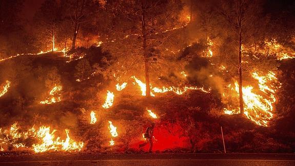 Un bombero trabaja en la extinción de las llamas de un incendio forestal en Clearlake, California.