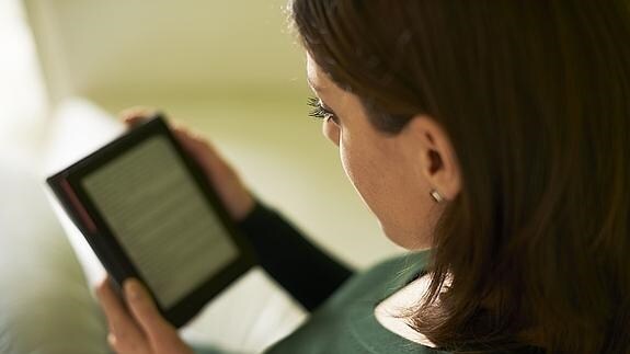 Una joven lee en un libro electrónico.