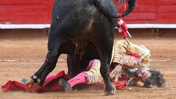 José Tomás es embestido por su primer toro de la tarde, 'Bellotero'. 