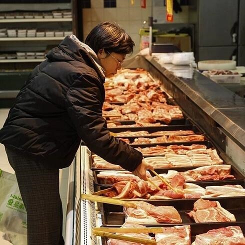 Una mujer escoge carne en un supermercado.