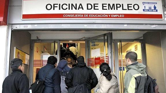 Ciudadanos forman cola en una oficina de empleo.