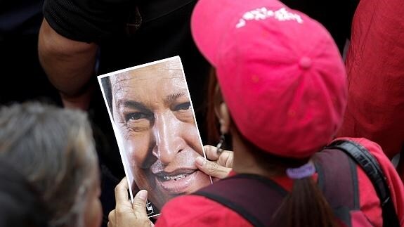 Una mujer sostiene una fotografía de Maduro. 